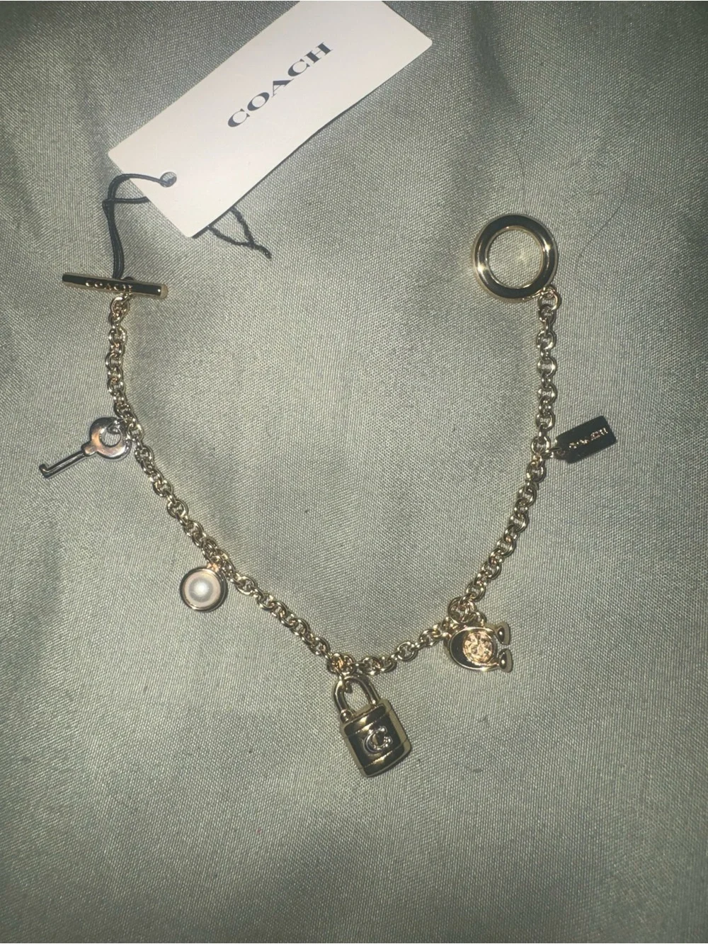 Coach Gold tone Charm Bracelet with Padlock, Key and Pearl Accents CD855 A31